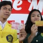 mahasiswa dan mahasiswi sedang memegang kartu jakarta mahasiswa unggul kjmu